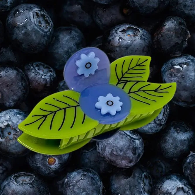 image of blueberry hair claw sitting on pile of real  blueberries 